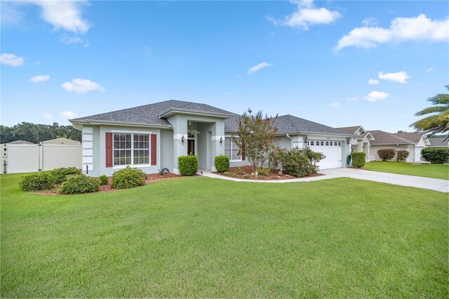 3967 SE 99th St, Belleview, FL 34420 - view of front of property with a front lawn, an attached garage, fence, and concrete driveway