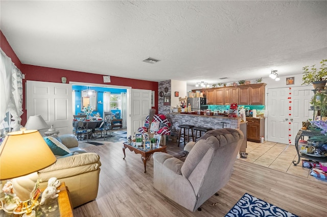 living room featuring a textured ceiling and light hardwood / wood-style floors