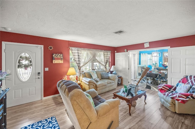 living room featuring light hardwood / wood-style floors and a textured ceiling