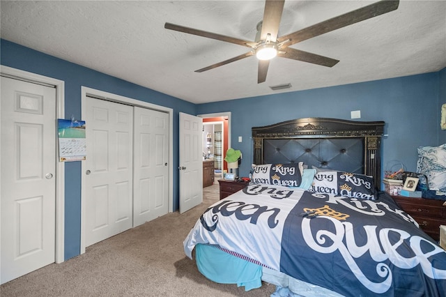 carpeted bedroom with ceiling fan and a textured ceiling