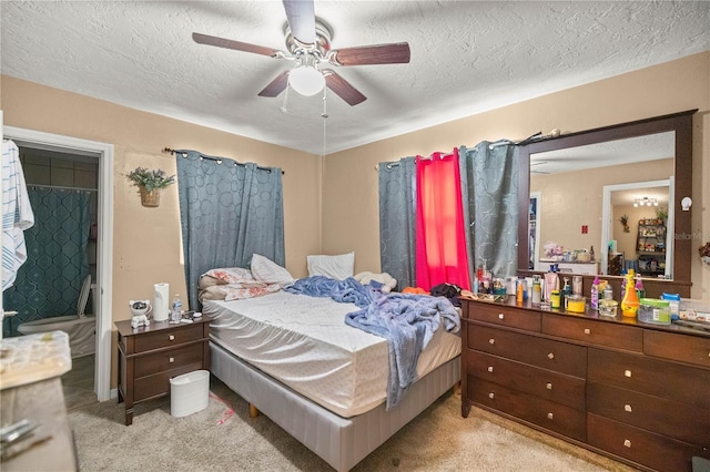 carpeted bedroom with ceiling fan and a textured ceiling