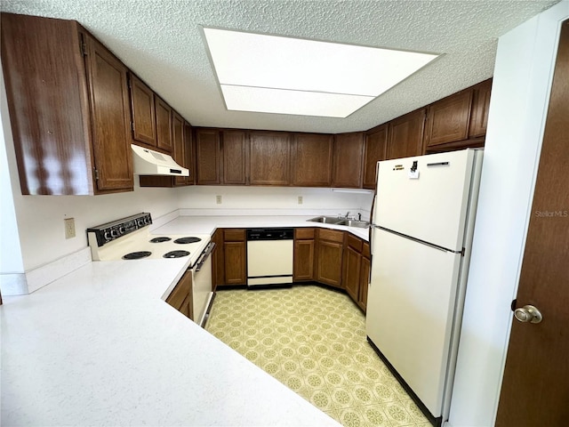 kitchen featuring white appliances, sink, dark brown cabinets, and a textured ceiling