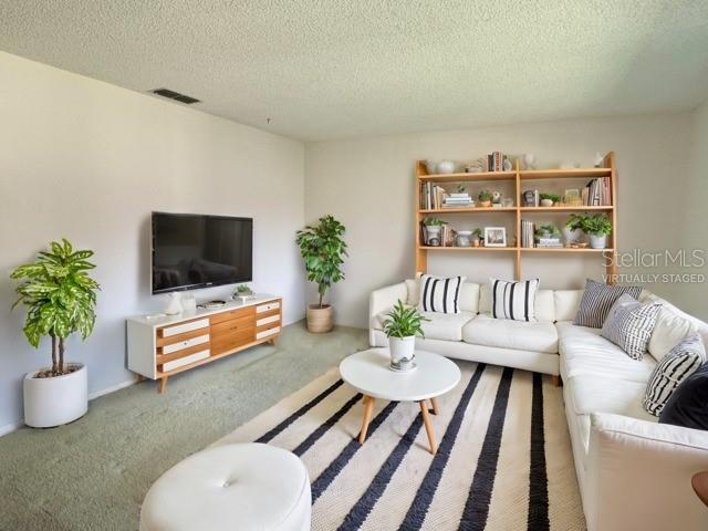 carpeted living room with a textured ceiling