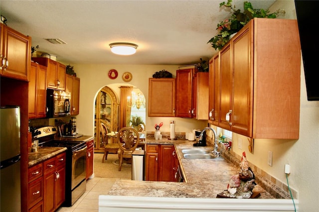 kitchen with kitchen peninsula, light tile patterned floors, stainless steel appliances, and sink