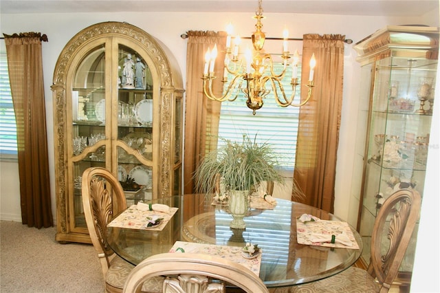 dining area featuring a notable chandelier, plenty of natural light, and carpet