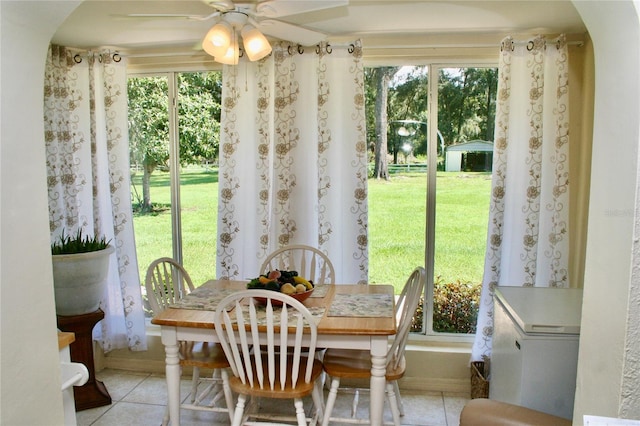 tiled dining area with ceiling fan and a healthy amount of sunlight