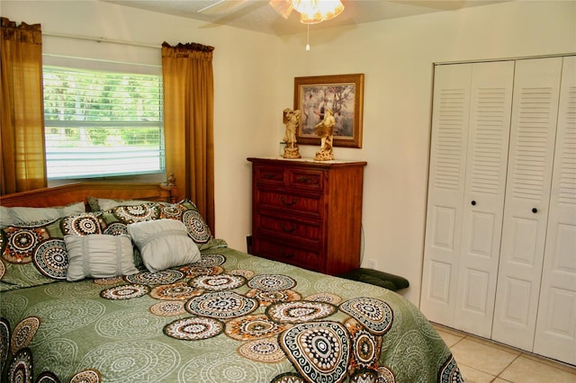 bedroom featuring light tile patterned floors, a closet, and ceiling fan