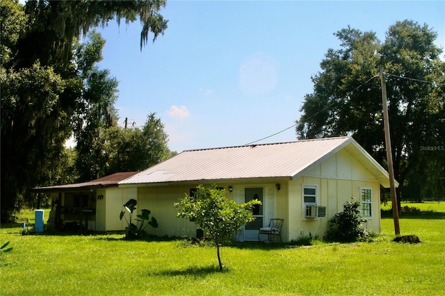 rear view of property featuring cooling unit and a yard