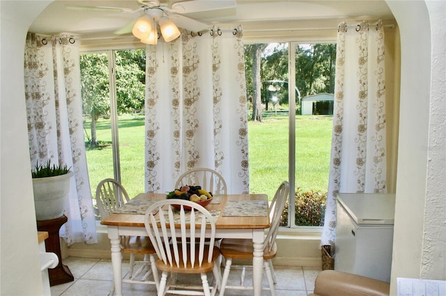 tiled dining space featuring ceiling fan and a healthy amount of sunlight