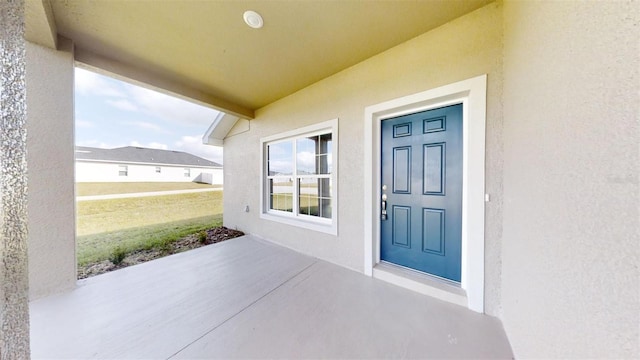 property entrance featuring a yard and a patio