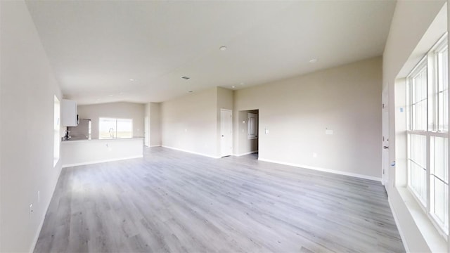 unfurnished living room featuring sink and light hardwood / wood-style flooring