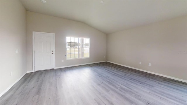 empty room with light hardwood / wood-style floors and lofted ceiling