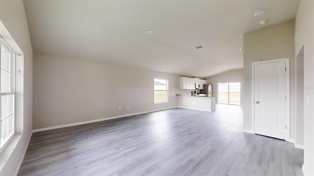 unfurnished living room with light hardwood / wood-style flooring and vaulted ceiling