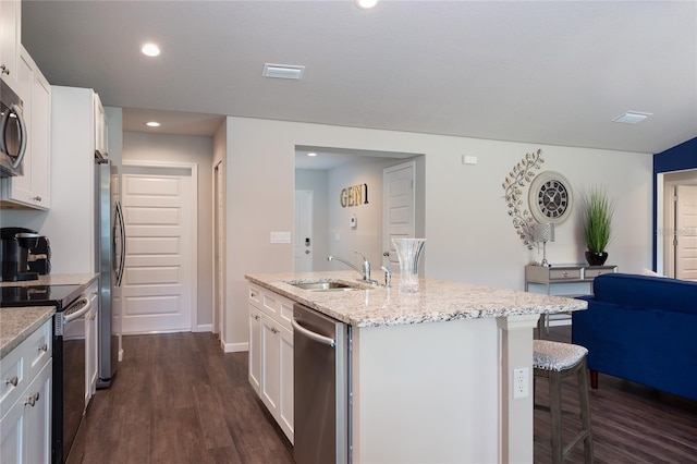 kitchen featuring stainless steel appliances, sink, light stone countertops, white cabinets, and dark wood-type flooring