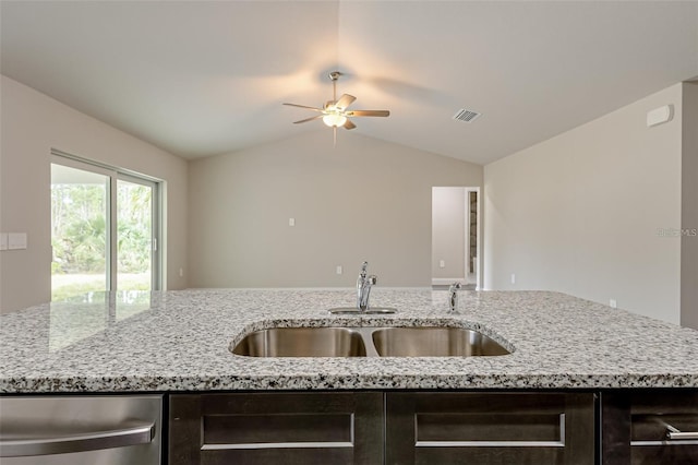 kitchen with sink, ceiling fan, lofted ceiling, and light stone countertops