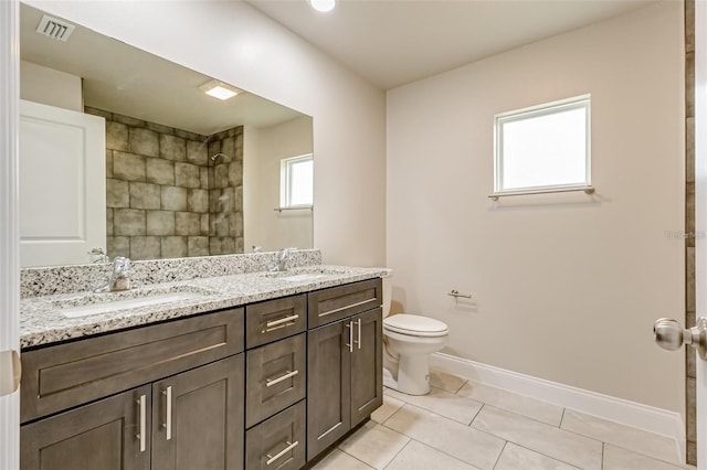 bathroom with tile patterned flooring, toilet, and dual bowl vanity