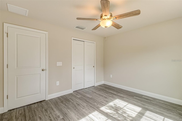 unfurnished bedroom featuring hardwood / wood-style flooring, a closet, and ceiling fan