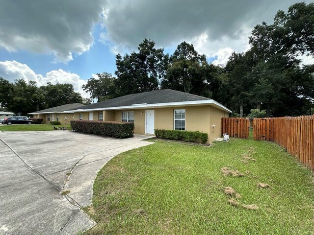 single story home featuring a front lawn