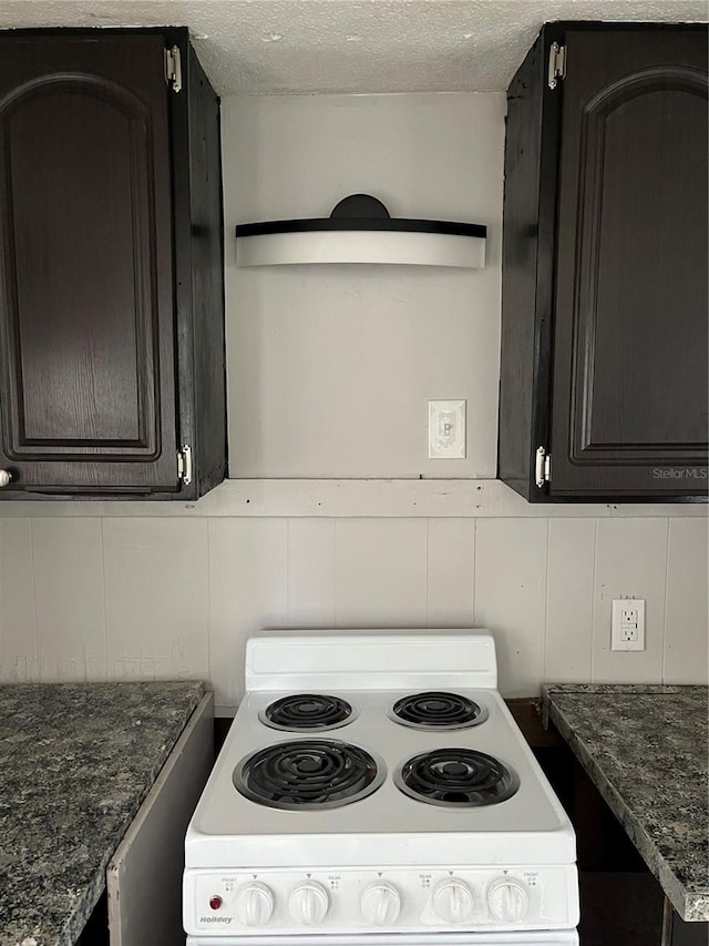 kitchen with white electric range oven, a textured ceiling, and dark stone counters