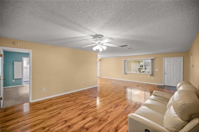 living room featuring ceiling fan, carpet, and a textured ceiling