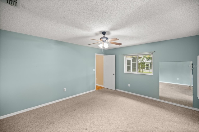 empty room with a textured ceiling, carpet flooring, and ceiling fan