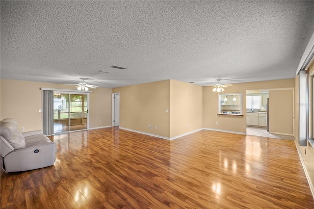 unfurnished living room with ceiling fan and light hardwood / wood-style flooring