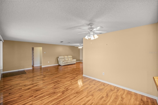 unfurnished living room with a textured ceiling, light hardwood / wood-style flooring, and ceiling fan