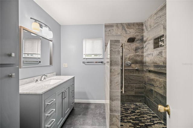 bathroom with tile patterned flooring, vanity, and tiled shower