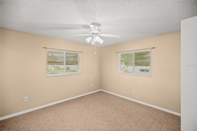 carpeted spare room featuring a textured ceiling and ceiling fan