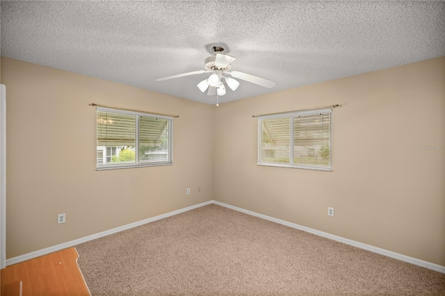 carpeted spare room with ceiling fan and a textured ceiling