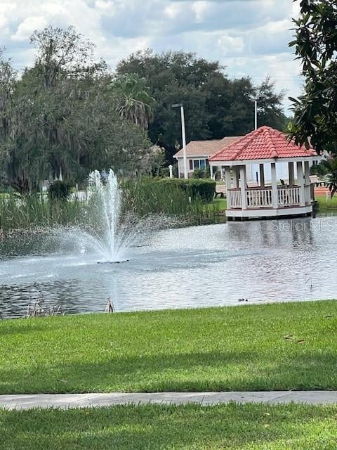 surrounding community with a water view and a yard