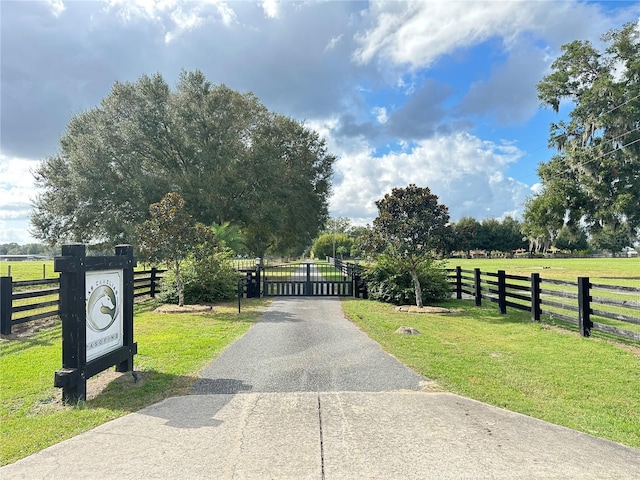 view of gate featuring a rural view and a yard