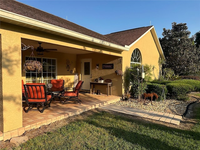 rear view of property with a lawn, ceiling fan, and a patio