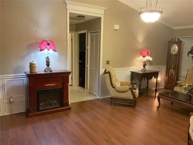 sitting room featuring wood-type flooring and ornamental molding