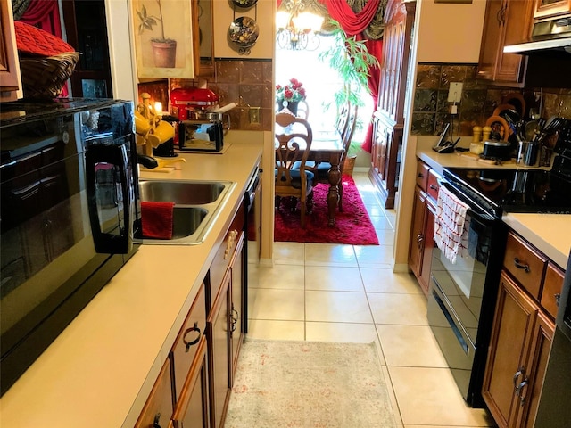 kitchen with backsplash, electric range, sink, and light tile patterned floors