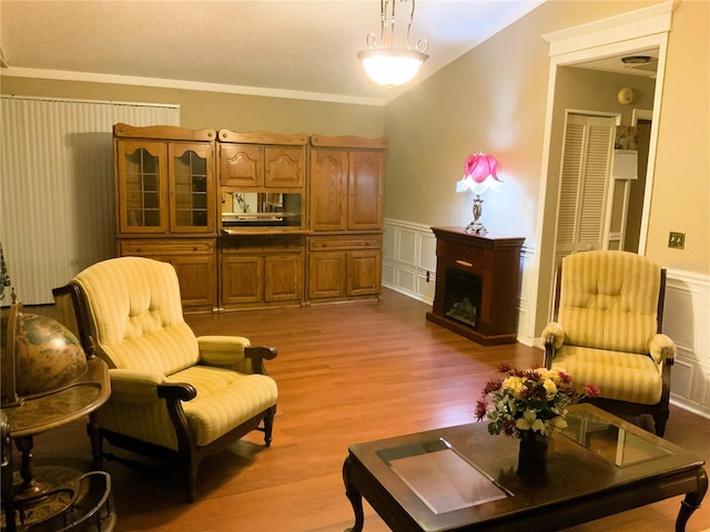 living room with light hardwood / wood-style flooring and crown molding