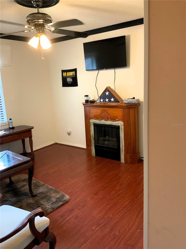 living room with ceiling fan, dark wood-type flooring, and ornamental molding