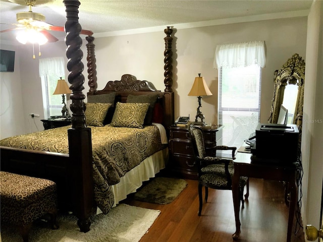 bedroom with hardwood / wood-style floors, a textured ceiling, ceiling fan, and crown molding