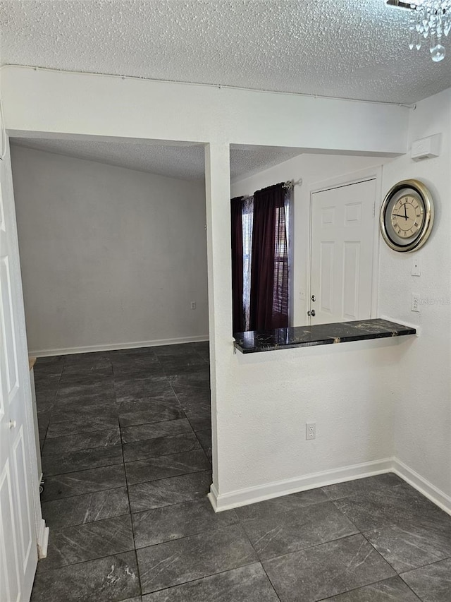 unfurnished room featuring a textured ceiling