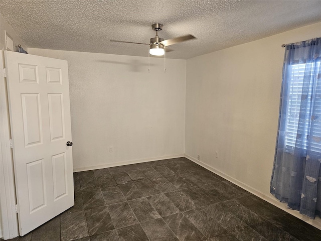 unfurnished room with ceiling fan and a textured ceiling