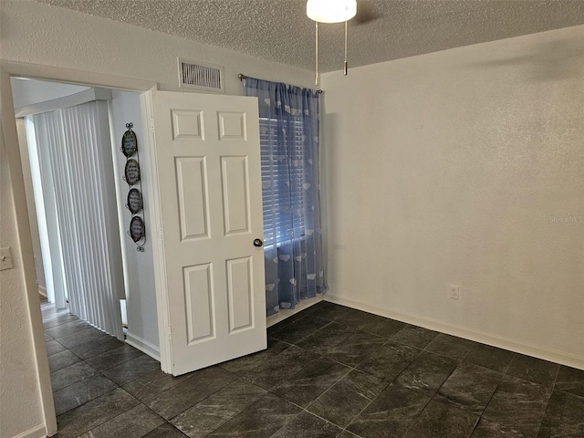 spare room with a textured ceiling