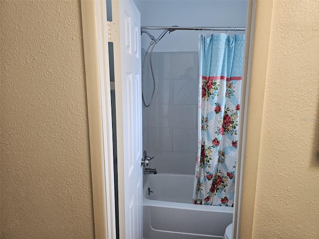 bathroom featuring shower / tub combo with curtain and toilet