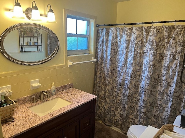 bathroom with tile walls, decorative backsplash, vanity, and toilet