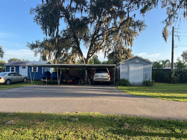 exterior space featuring a front lawn, a storage shed, and a carport