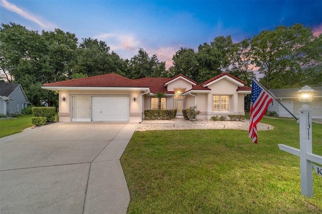 view of front of house with a garage and a yard