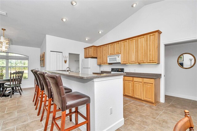 kitchen with white appliances, a notable chandelier, light tile patterned flooring, and an island with sink