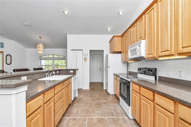 kitchen with an inviting chandelier, sink, pendant lighting, light tile patterned floors, and white appliances