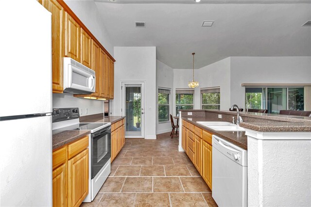 kitchen featuring sink, an inviting chandelier, tile patterned floors, white appliances, and hanging light fixtures