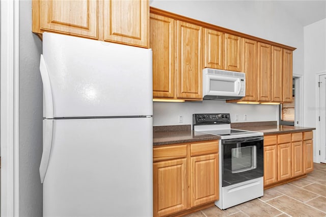 kitchen featuring white appliances and dark countertops