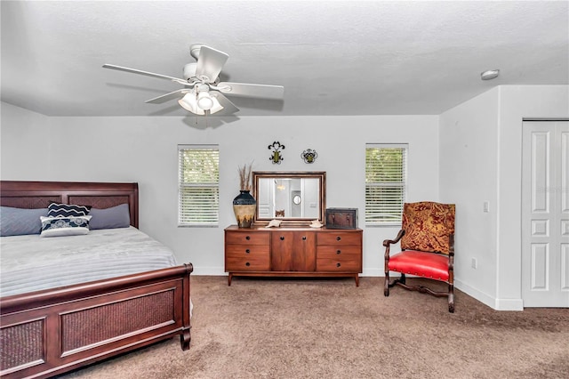 bedroom with light carpet, ceiling fan, a textured ceiling, and baseboards